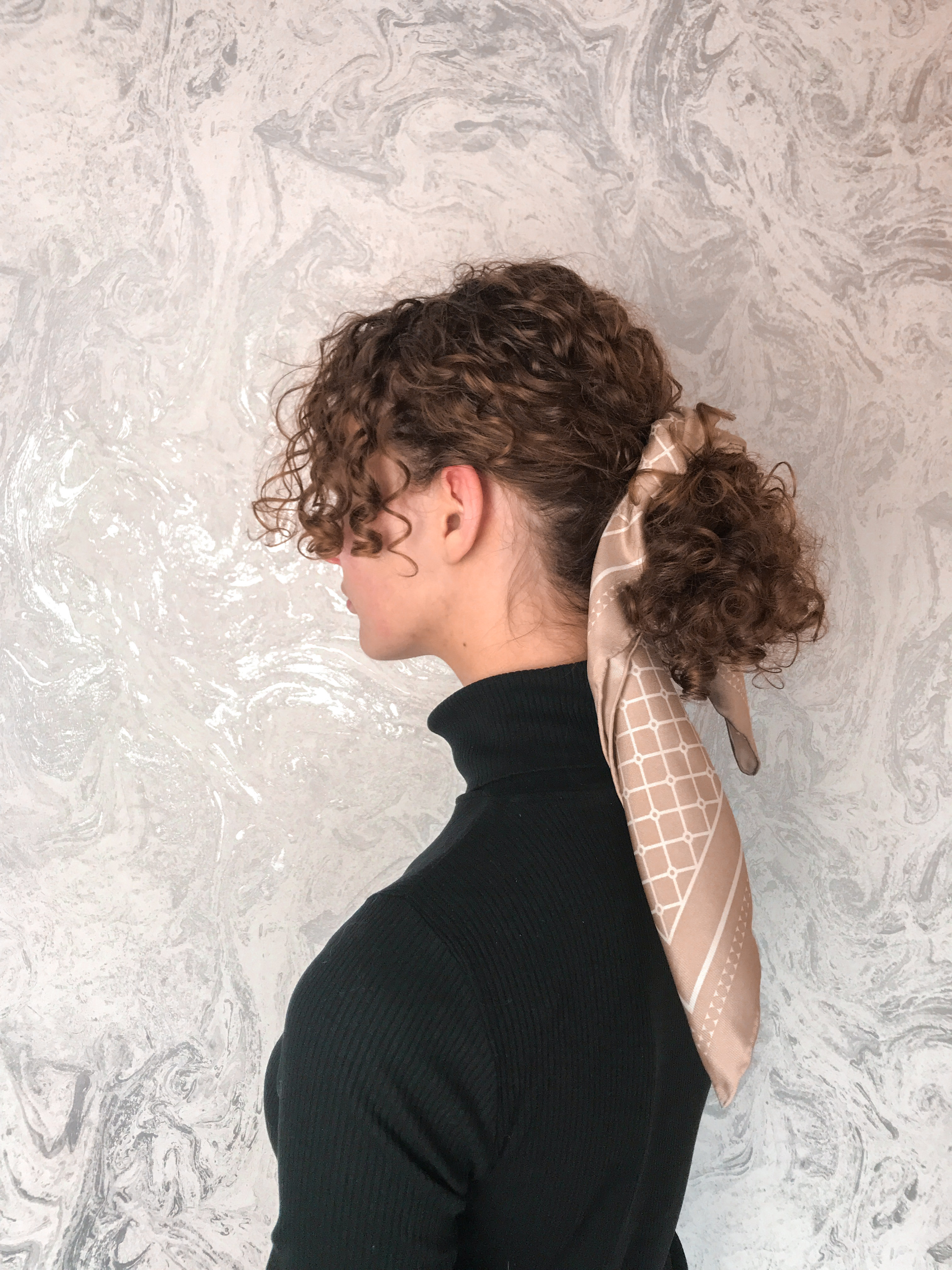 Curly low ponytail with silk scarf for wedding